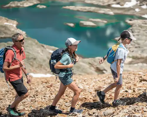 Groupe de randonneurs marchant en montagne : enfants et parents